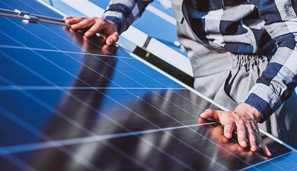 Manos tocando un panel solar